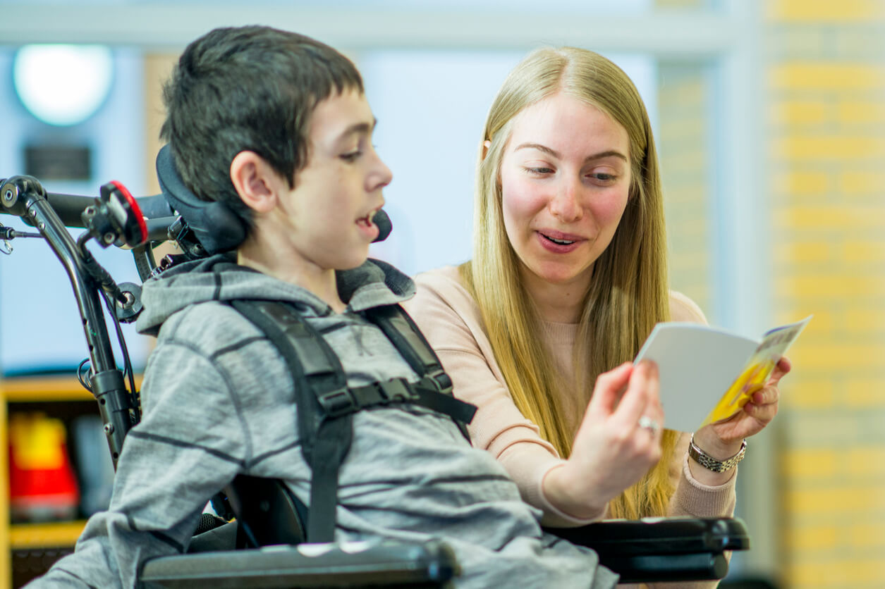 FSJ: Junge Frau hilft Kind im Rollstuhl beim lesen