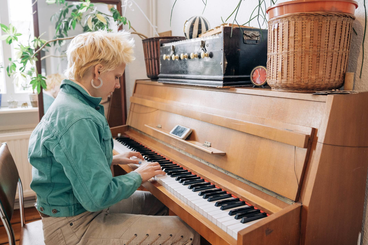 Junge blonde Frau spielt auf einem alten Klavier