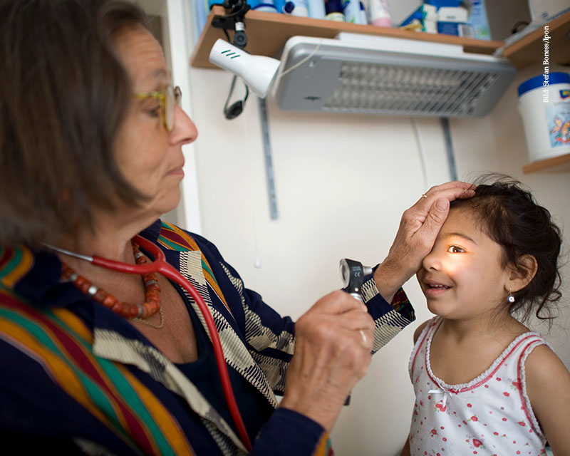 Ärztin untersucht Augen eines kleines Mädchens