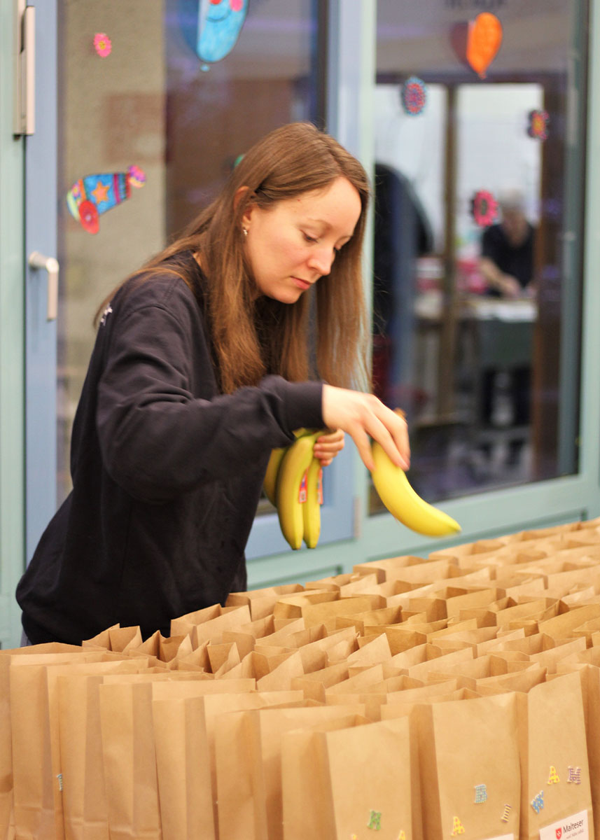 Eine Frau packt Bananen in Papiertüten