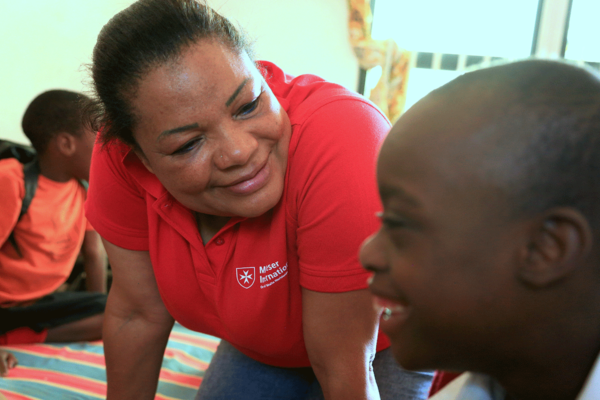Malteser Mitarbeiterin aus Selbsthilfegruppe für behinderte Kinder in Uganda