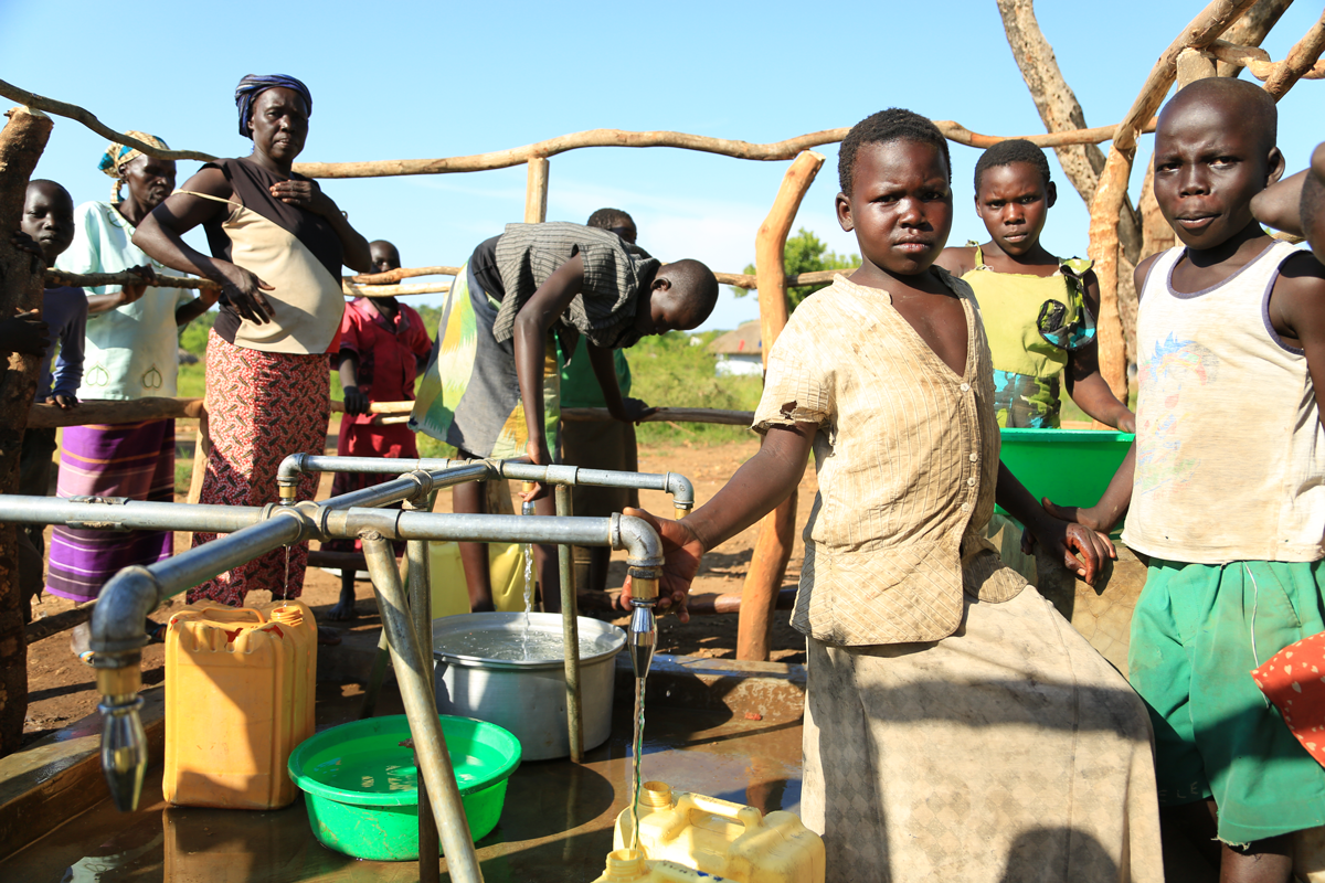 Flüchtlinge holen Wasser am Brunnen in Uganda