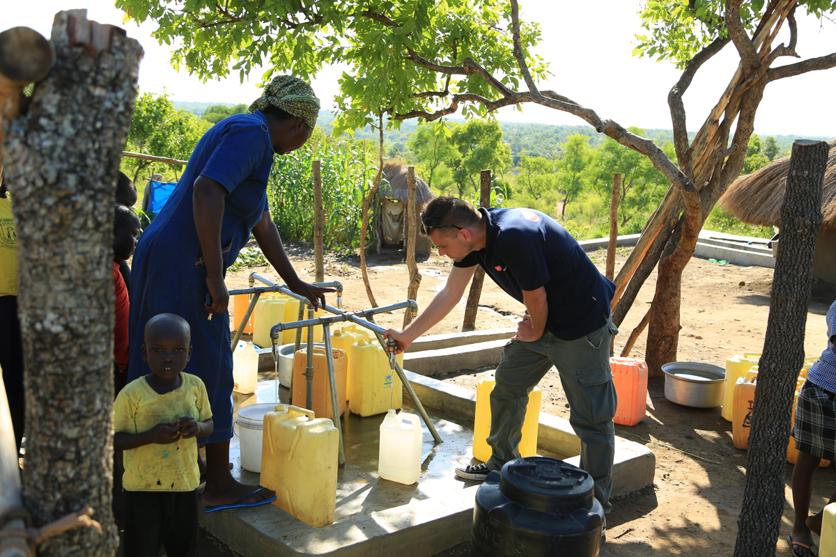 Menschen holen Wasser am Brunnen in Uganda