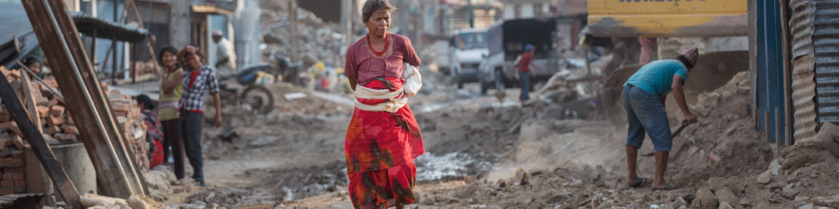 Frau in Nepal in den Trümmern ihres Dorfes