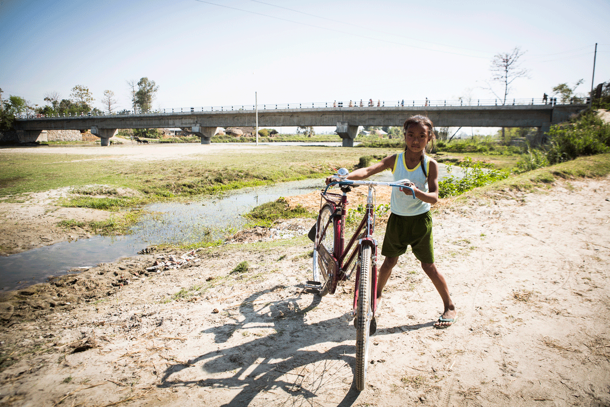 Kind an einem Fluss in Nepal