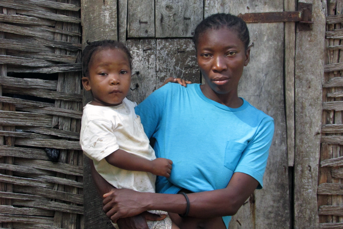 Fischerin aus Haiti mit ihrem Kind auf dem Arm
