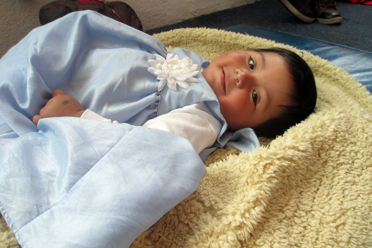 Baby aus Mexiko liegt auf einer Decke 