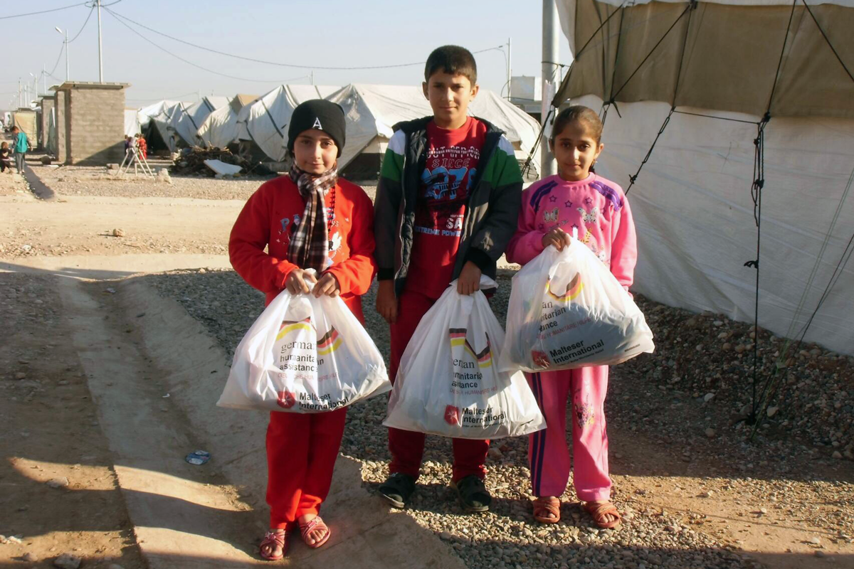 Kinder aus dem Irak mit Anziehsachen für den Winter