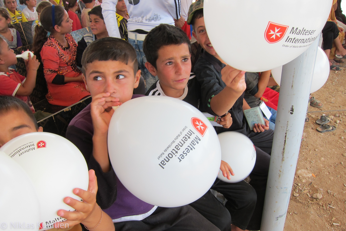 Bei der Verteilung von Wintersachen bekommen die Flüchtlingskinder auch Ballons