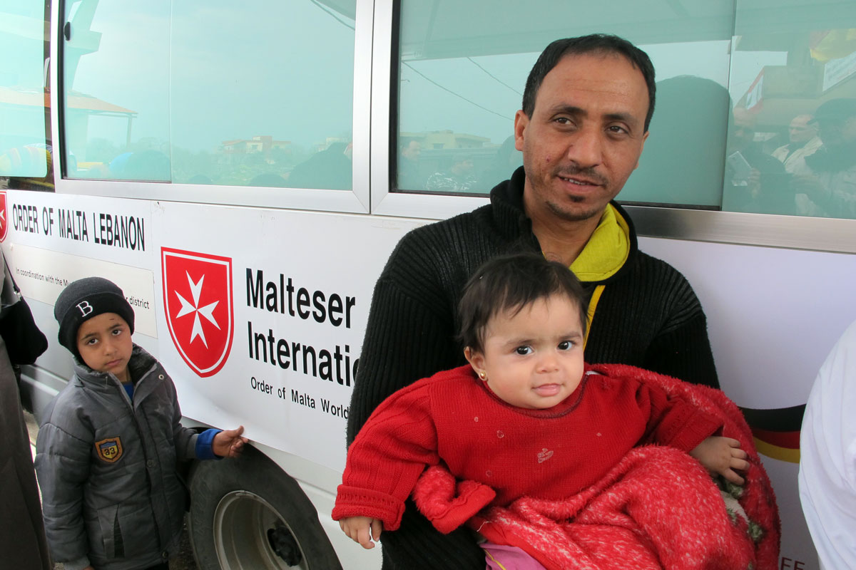 Vater und Tochter vor mobiler Gesundheitsstation im Libanon