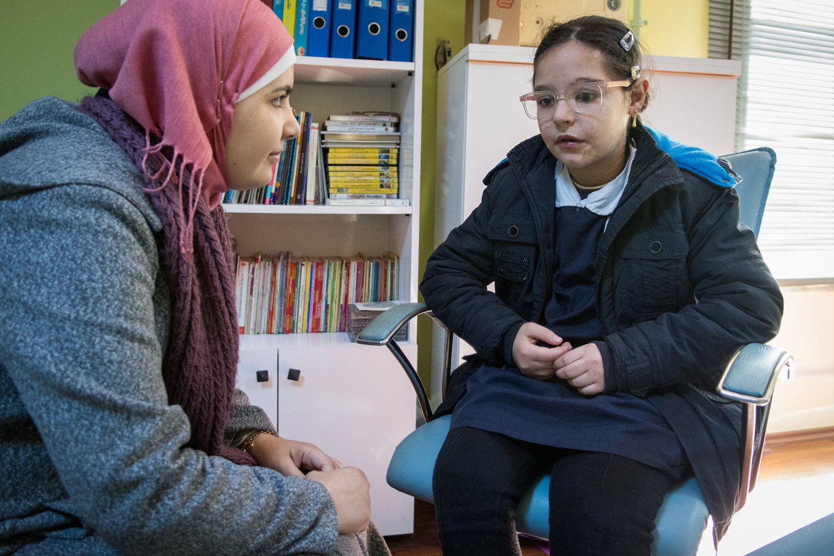 Mädchen aus Syrien spricht mit Lehrerin