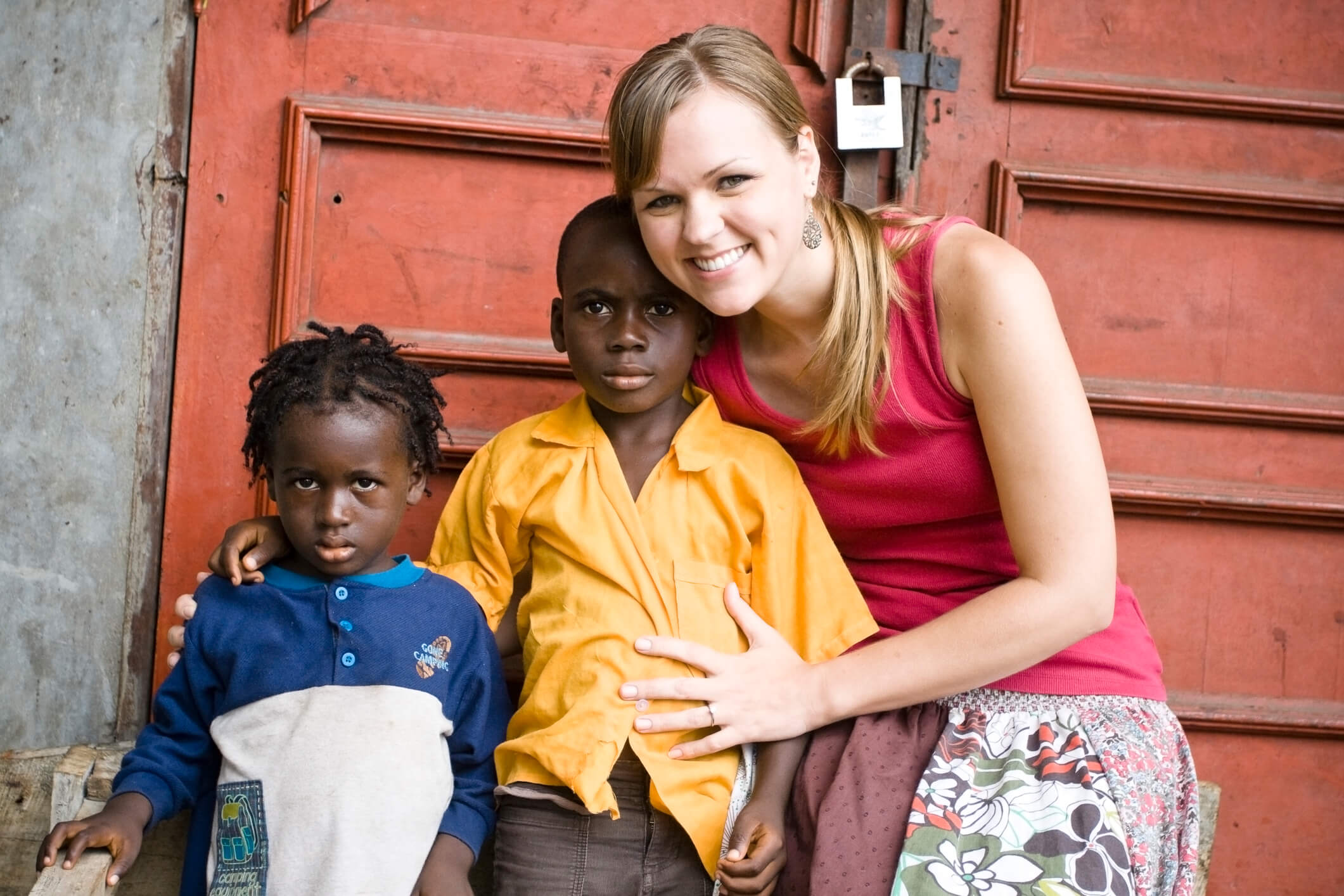 Junge europäische Frau posiert mit zwei afrikanischen Kindern