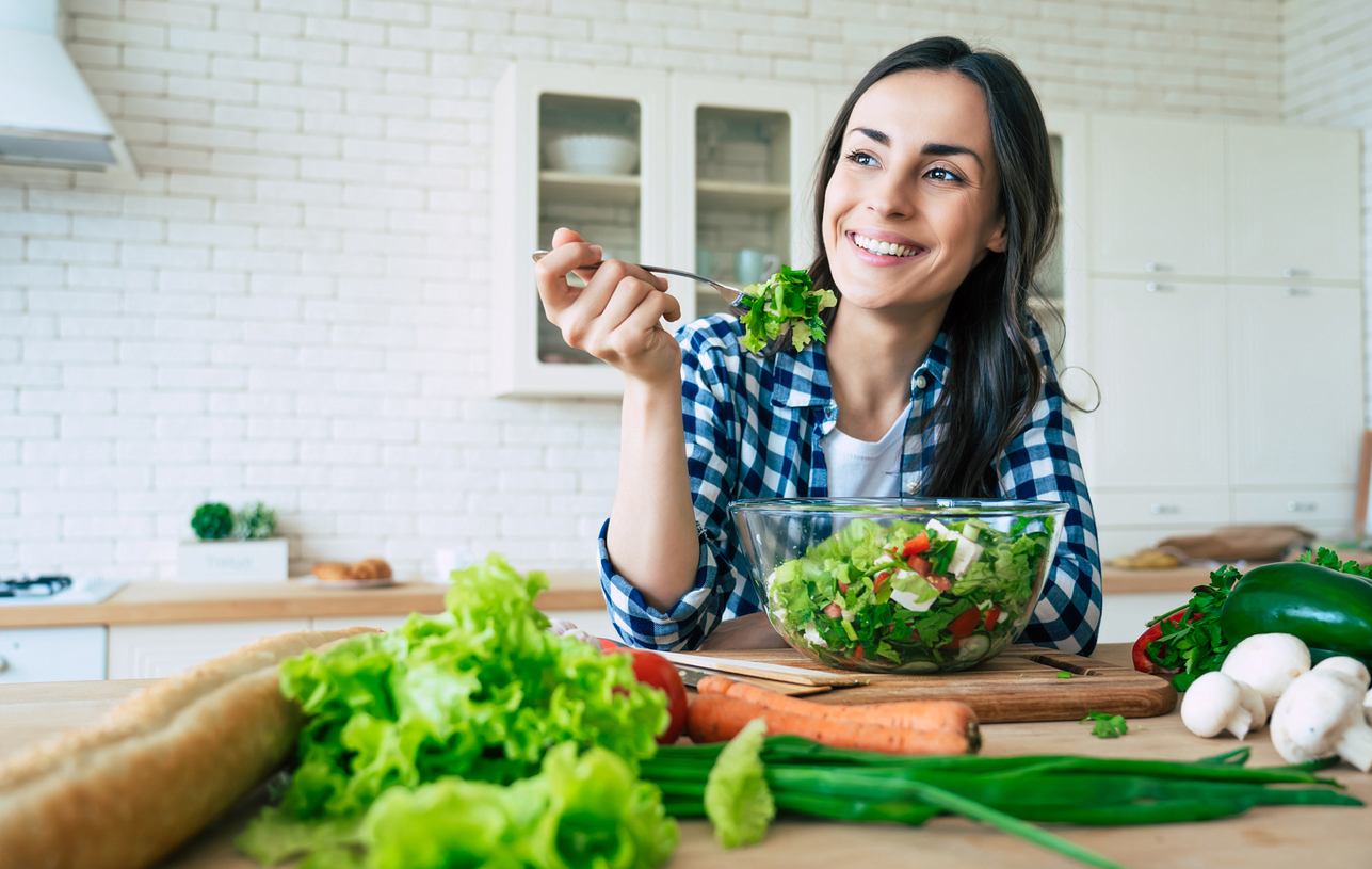 Lächelnde Frau isst Salat