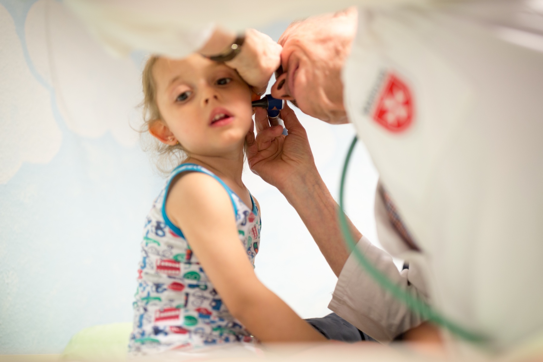 Ein Arzt untersucht das Ohr eines kleinen Mädchens