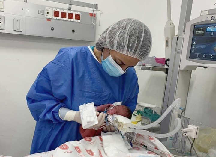 Ärztin hält ein frühgeborenes Baby auf einer Säuglingsstation