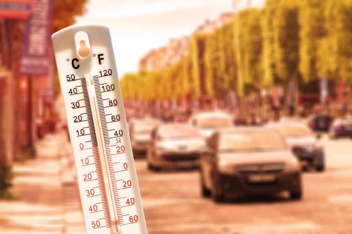 Thermometer im Vordergrund und Autos im Hintergrund.