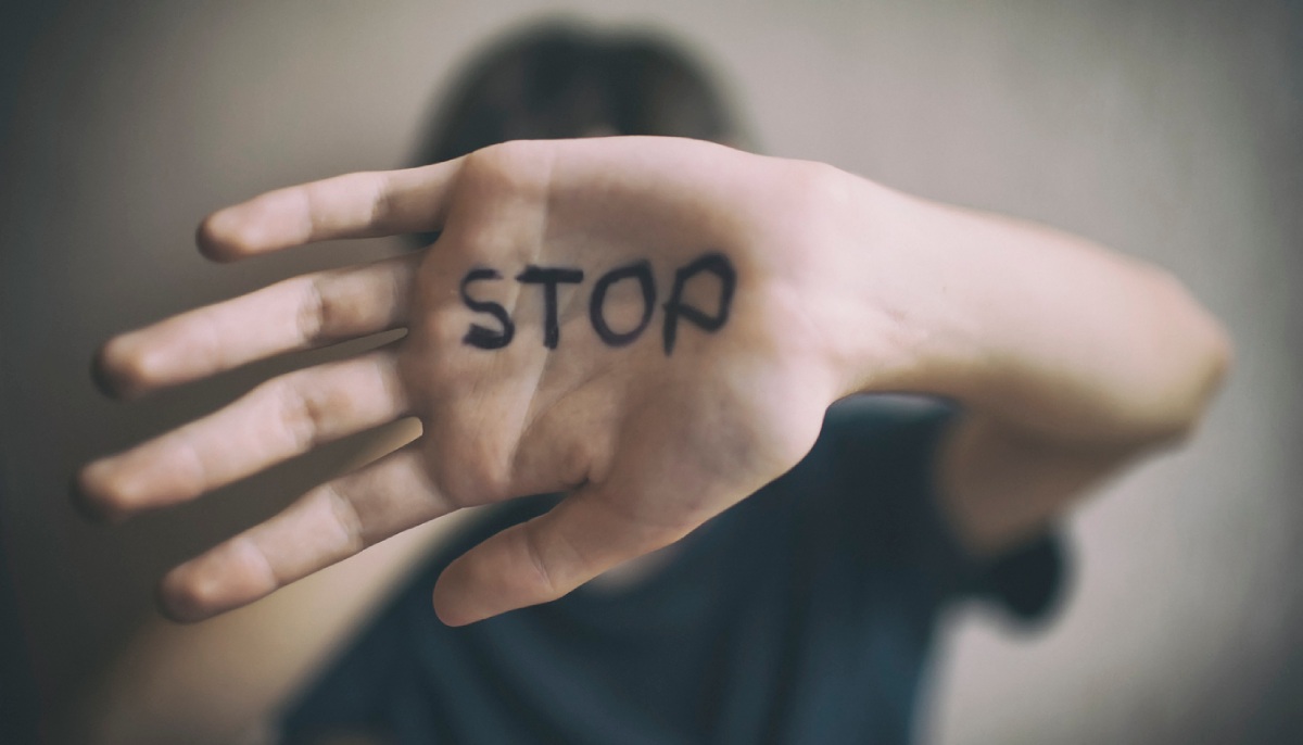 Vorgestreckte Handfläche mit der Aufschrift „Stop“