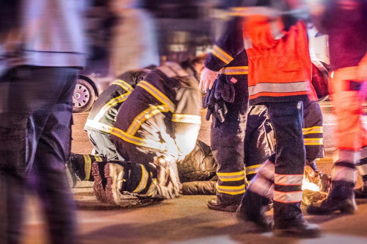 Rettungskräfte versorgen ein Unfallopfer auf einer nächtlichen Straße