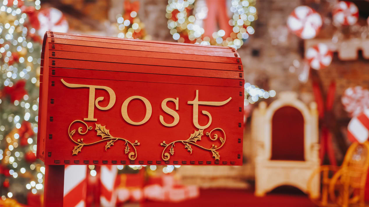 Ein roter Briefkasten vor weihnachtlicher Kulisse