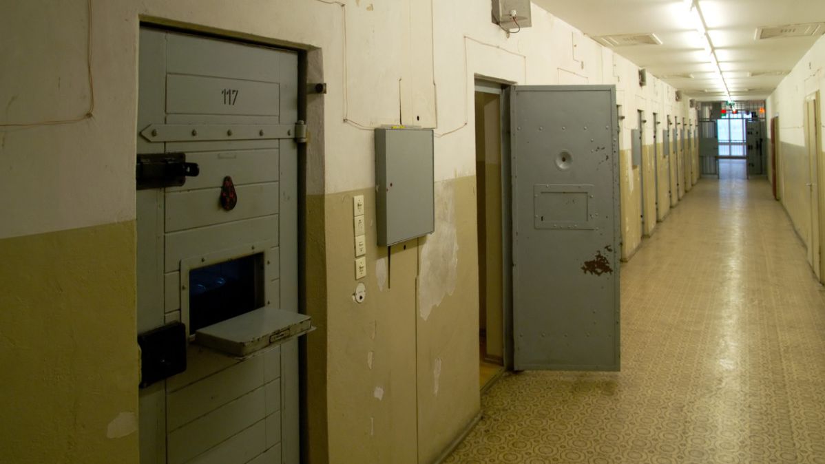 Ein Gefängnisflur mit verstärkten Zellentüren.