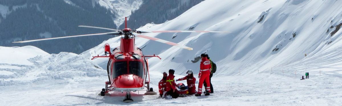 Helfende der Bergrettung mit einem Hubschrauber im Schnee