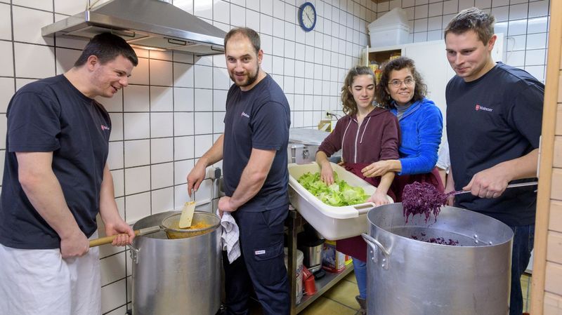 Freiwillige Helferinnen und Helfer der Malteser kochen gemeinsam in einer Großküche.