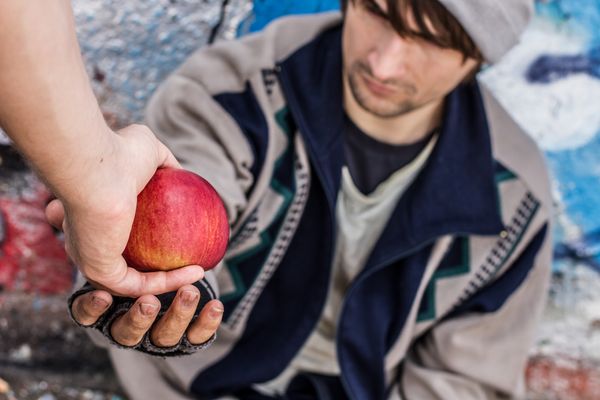 Obdachloser der Apfel annimmt 