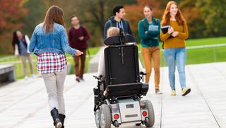 Junge Studierende, darunter eine Person im Rollstuhl