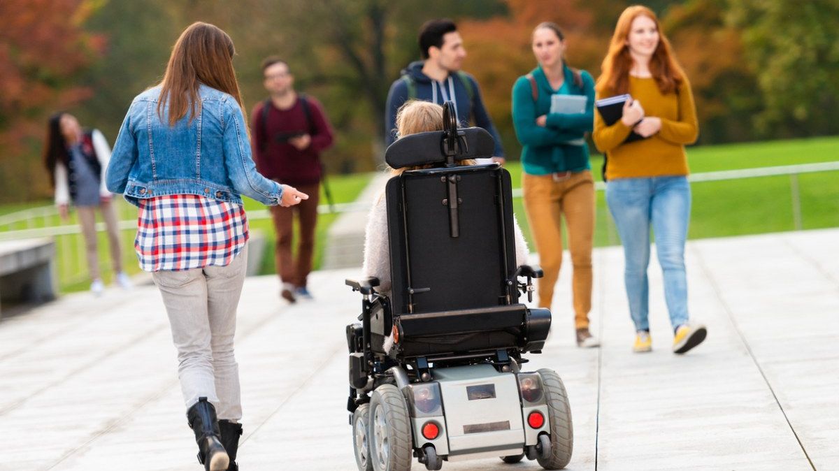 Junge Studierende, darunter eine Person im Rollstuhl