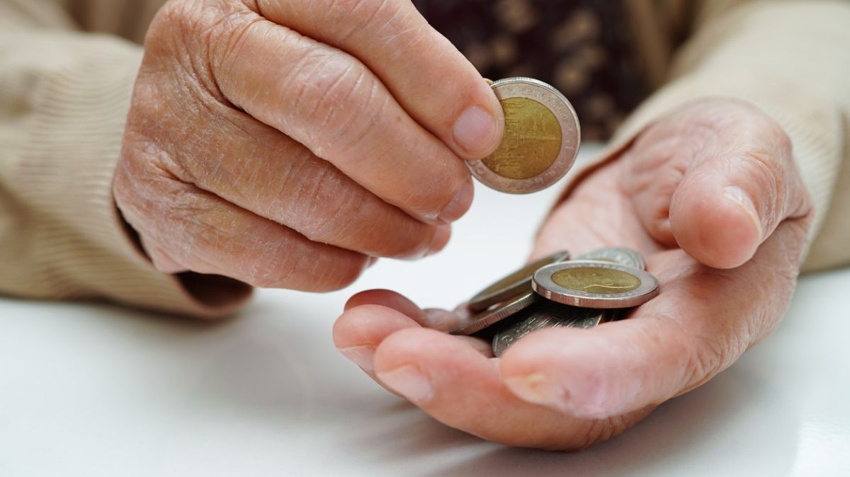 Eine Hand, in der mehrere Zwei-Euro-Geldstücke liegen.