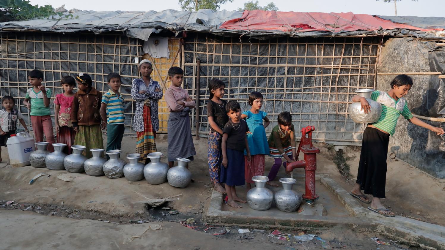 Kinder stehen in einem Flüchtlingslager für Wasser an.
