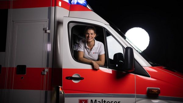 Eine lächelnde junge Frau in einem Rettungswagen