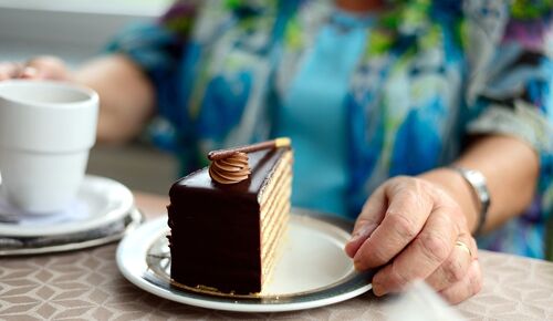 Ausschnitt einer Seniorin, die Kuchen isst