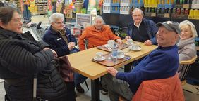 Nach der ersten Einkaufsfahrt im neuen Wagen und der Unterstützung im Einkaufszentrum unterhalten sich die Seniorinnen und Senioren zusammen mit den Ehrenamtlichen noch angeregt bei einem gemeinsamen Kaffee. 