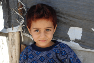 Flüchtlingsjunge im Irak mit blauem Wollpullover