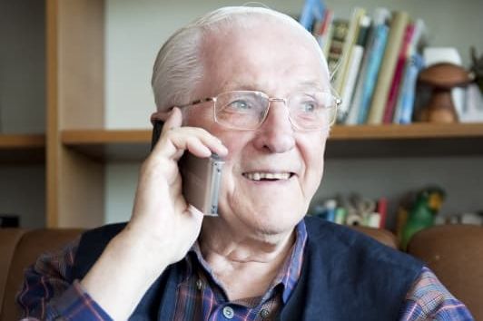 Älterer Mann spricht am Telefon.