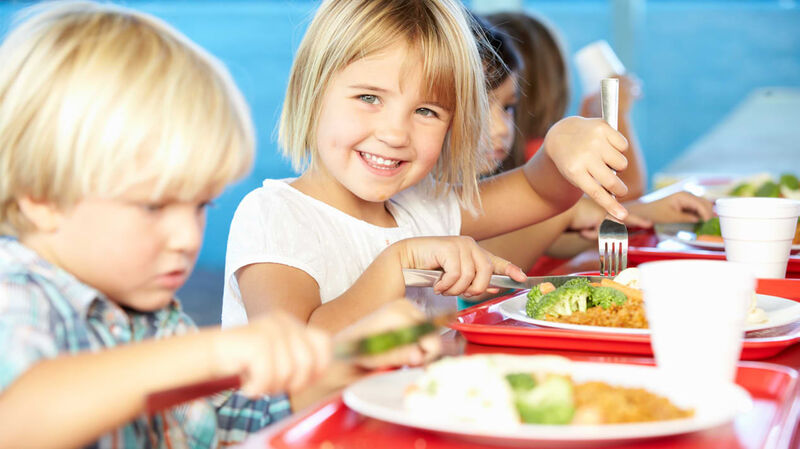 Kinder essen an einem Tisch