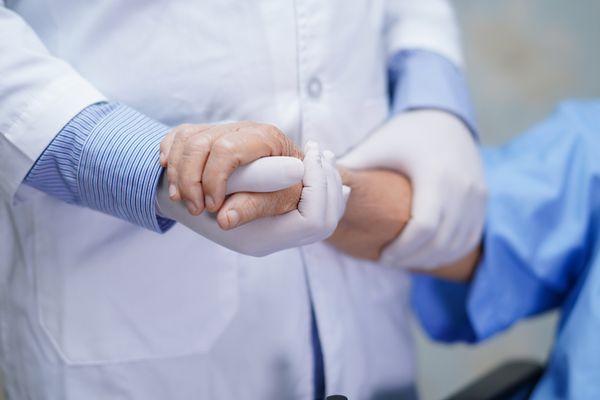 Arzt hält Hand einer Patientin 