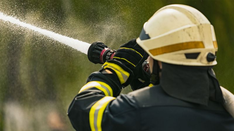 Ein Feuerwehrmann mit einem Feuerwehrschlauch