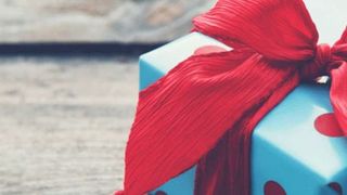 Geschenk in blauem Papier mit roter Schleife