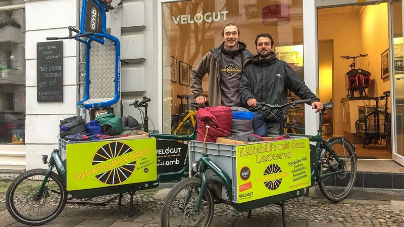 Frederyk und Elias präsentieren ihre Lastenräder vor dem Fahrradladen.
