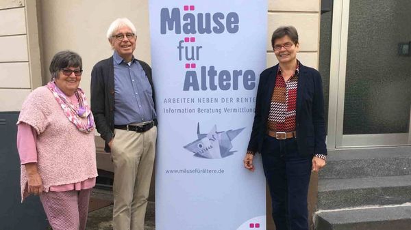 Drei Senioren werben für ein Straßenplakat mit dem Titel: Mäuse für Ältere.