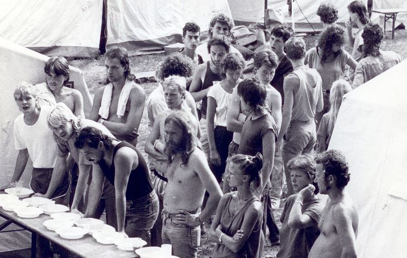 Flüchtlinge stehen in einer Schlange bei der Essensausgabe.