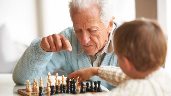 Ein alter Mann spielt Schach mit einem Jungen.