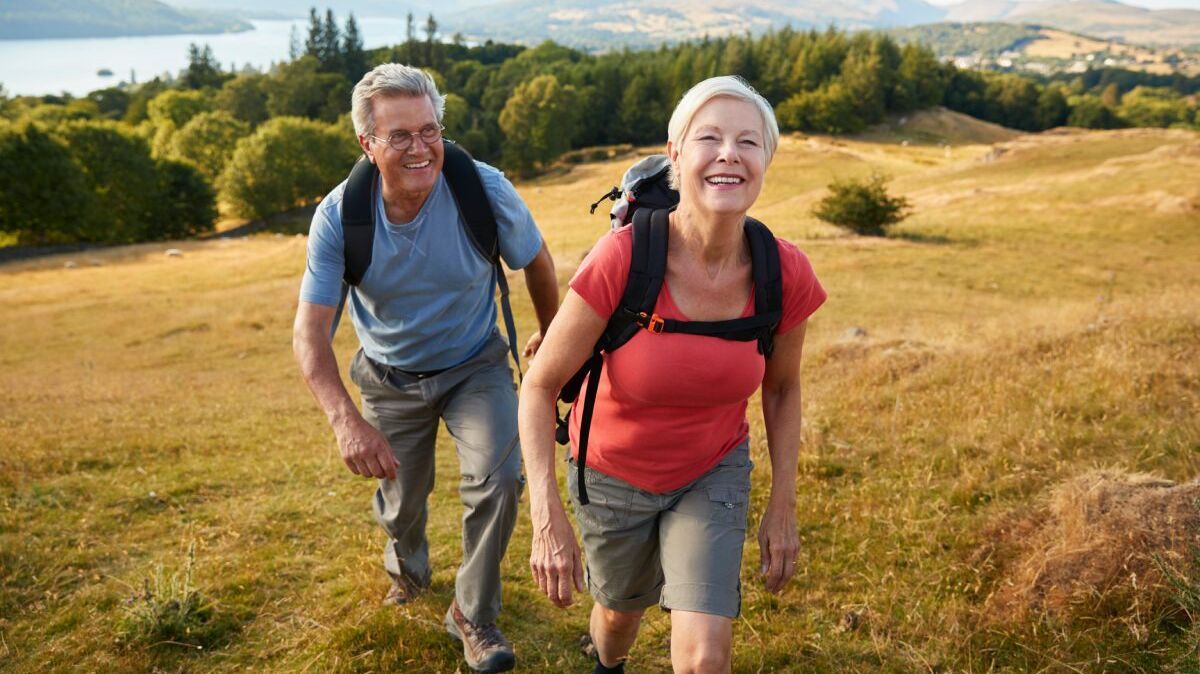 Ein lächelndes älteres Paar wandert in der Natur