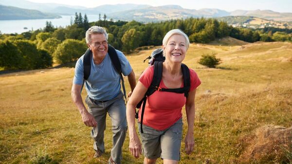 Ein lächelndes älteres Paar wandert in der Natur