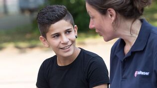 Eine junge Malteser Integrationslotsin unterhält sich mit einem Jungen.