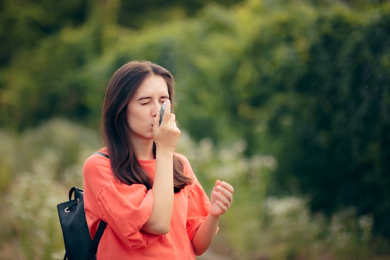Eine junge Frau benutzt einen Inhalator