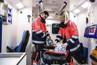 Freiwillige im Rettungswagen beim Einsortieren und Aufrüsten der medizinischen Bestände als Vorbereitung für den nächsten Einsatz