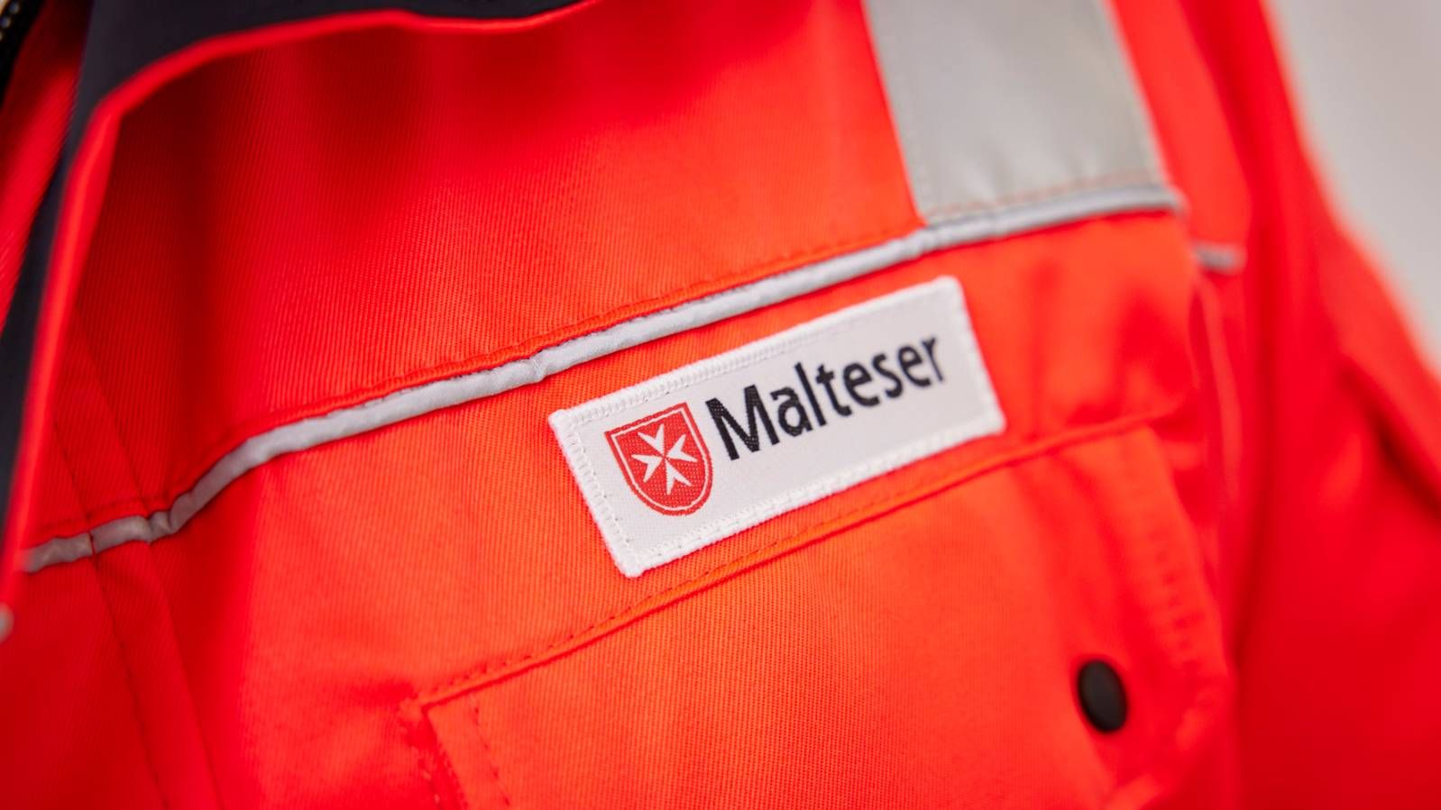 Malteser Logo auf einer roten Jacke.